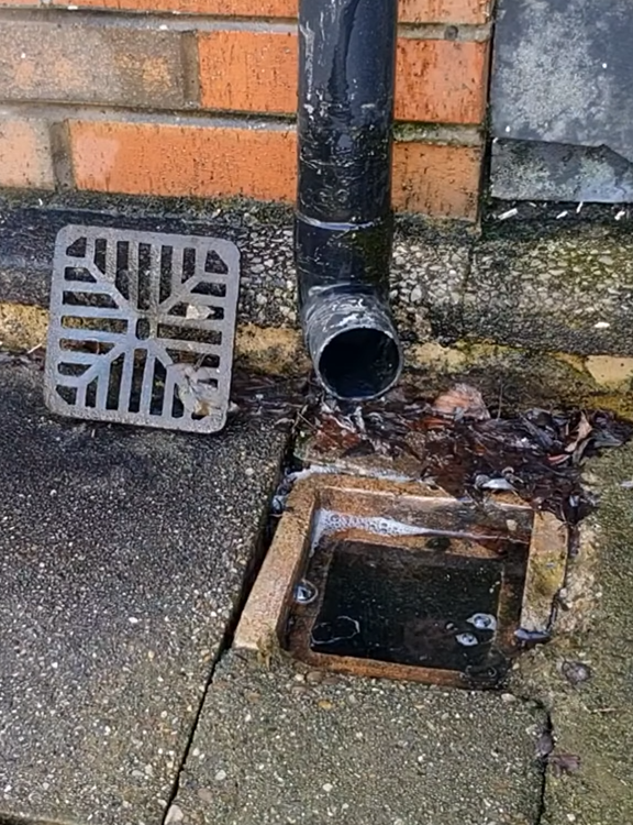 Drainage repair team working on exposed underground pipework